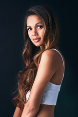 Poster - Glowing with natural beauty. Studio portrait of an attractive young woman posing against a dark background.