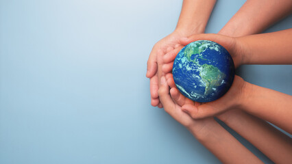 group of hands holding earth globe on blue background, international human solidarity day concept, w