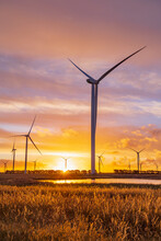 A Group Wind Turbines Silhouetted Against A Colourful Sunset Sky