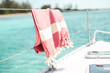 © Austockphoto - Red turkish towel hanging on wire railing of boat on the water