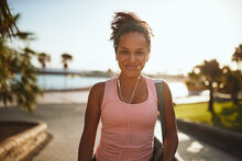 Sporty Woman Standing On A Promenade Carrying A Yoga Mat