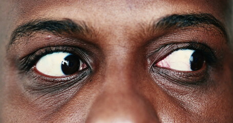 Extreme face close-up, macro eyes of black African man looking sideways