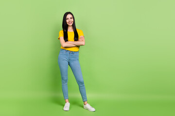 Wall Mural - Photo of dreamy pretty woman wear yellow t-shirt arms crossed empty space isolated green color background