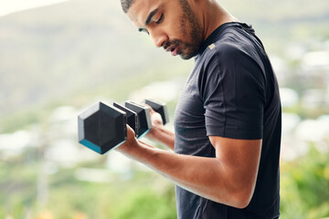 Canvas Print - Focused on his fitness transformation. Cropped shot of a sporty young man lifting weights outside.