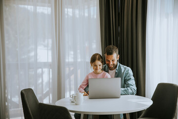 Wall Mural - Father and daughter using laptop computer together