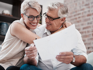 Poster - The energy housed in my favourite person. Shot of a mature couple going through paperwork on the sofa at home together.