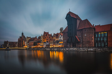 Wall Mural - Beautiful architecture of the old town in Gdansk by the Motlawa river with a historic port crane at night. Poland, November 2021