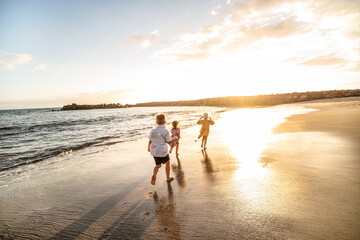 Lovely little kids playing at the beach. Cute boy and girls have fun together, running on the sand  Childhood.