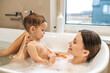 © zinkevych - Smiling woman taking a bath with her baby