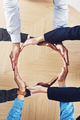Poster - Its our world and were all living in it. High angle shot of a group of unidentifiable businesspeople forming a circle with their hands.