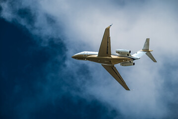 Airplane Jet flying overhead against blue sky and white clouds