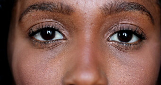 close-up african young woman eyes looking at camera, macro closeup black girl eye