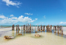 Wooden Poles In The Sand Of A Paradisiacal And Calm Beach