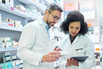 Poster - Nothing says well run pharmacy like teamwork. Shot of a mature man and young woman using a digital tablet together while working in a pharmacy.