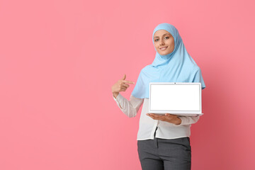 Wall Mural - Muslim secretary with laptop on color background