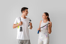 Sporty Young Couple With Skipping Ropes On Grey Background