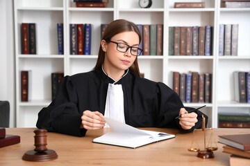 Poster - Female judge working at table in courtroom