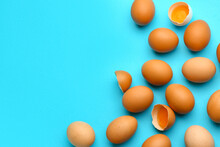 Cracked And Whole Chicken Eggs On Blue Background