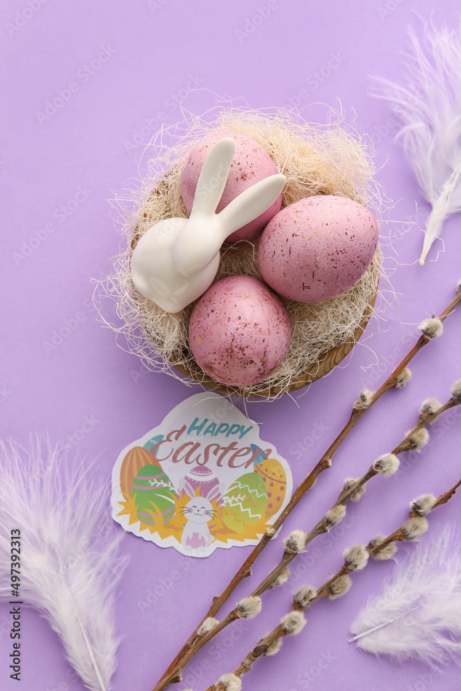 Beautiful Easter composition with eggs, pussy willow branches and feathers on lilac background