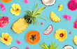 Creative layout made of tropical fruits and flowers. Flat lay. Food concept. Macro concept. Pineapple, papaya, dragonfruit , coconut and hibiscus flowers.
