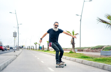 Canvas Print - latin senior man skateboard on bikeway and having fun in La Serena