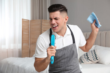 Wall Mural - Man with brush and rag singing while cleaning in bedroom