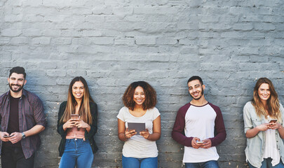 Aufkleber - Access to information, when and where we want it. Portrait of a group of young people using their wireless devices together outdoors.