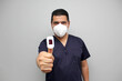 © Arlette - Latin adult man with medical uniform and mask shows a pulse oximeter in his hand to measure oxygenation in the finger with symptoms of Covid-19 in the new normal