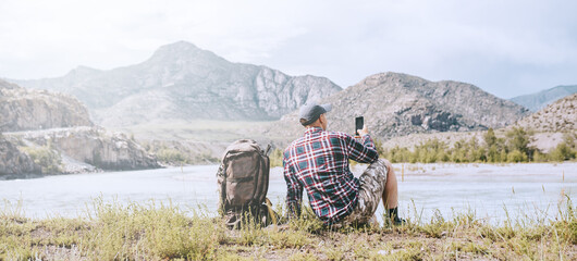 Wall Mural - Hiker using smart phone in the mountains