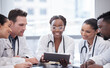 © Talia Mdlungu/peopleimages.com - Take a look at this. Cropped shot of a group of young doctors looking at a tablet during a meeting in the hospital boardroom.