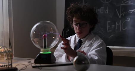 Wall Mural - schoolboy experimenting in physics class. young student doing physics experiment in the classroom.