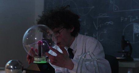 Wall Mural - a boy conducts physical experiments with electricity, a plasma ball, and a van de graaff generator.