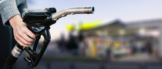 Wall Mural - Closeup of woman pumping gasoline fuel in car at gas station. Petrol or gasoline being pumped into a motor. Transport concept