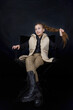 © zokov_111 - girl sitting on a chair holding her hair on a black background