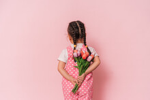 Little Girl With Bouquet Of Flowers Against Pink Background. Happy Mother's Day