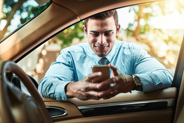 Aufkleber - Staying close to his network even when on the go. Shot of a young businessman using a cellphone while leaning against his car.