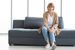 © offsuperphoto - senior woman suffering from knee ache on sofa