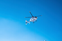 Police Helicopter Flying Above Against Blue Sky On Sunny Day