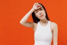 Young Woman Of Asian Ethnicity 20s Years Old In White Tank Top Put Hands On Head Rub Temples Having Headache Suffering From Migraine Feel Bad Seedy Isolated On Plain Orange Background Studio Portrait.