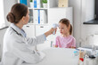© Syda Productions - medicine, healthcare and pediatry concept - female doctor or pediatrician measuring little girl patient's temperature with infrared forehead thermometer at clinic