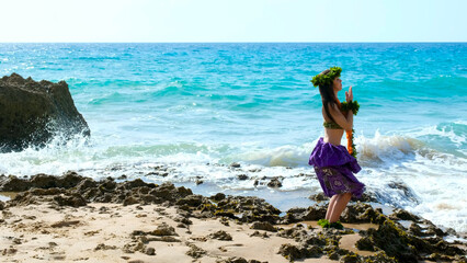 Wall Mural - Woman rests and poses happily on the beach wearing the typical hula dance costume. Hawaiian dance beauty. Exotic girl.