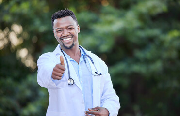 Canvas Print - Give good healthcare a thumbs up. Shot of a young male doctor showing a thumbs up in nature.