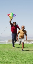 Vertical Video Of Happy African American Father With Son Flying Kite