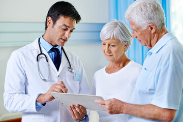 Poster - Thats completely within normal range. Shot of a handsome young doctor explaining results to a senior couple.