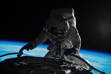 Wall Mural - female astronaut performing spacewalk, working on a outer part of a space craft