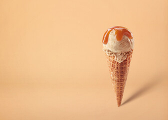 Wall Mural - Caramel ice cream scoop in waffle cone