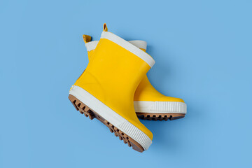 Wall Mural - A pair of child yellow rain boots on blue background