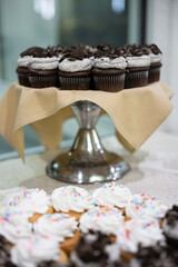 Poster - Vertical shot of small cupcakes with chocolate cream at the wedding table