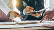 © Phushutter - Three of business people working together in the meeting room office with paper charts, discussing and planning concept.