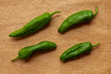 Green Raw Chili Peppers Top View On Paper Table. Anaheim Heirloom Variety Of Home-grown Chili Vegetable.